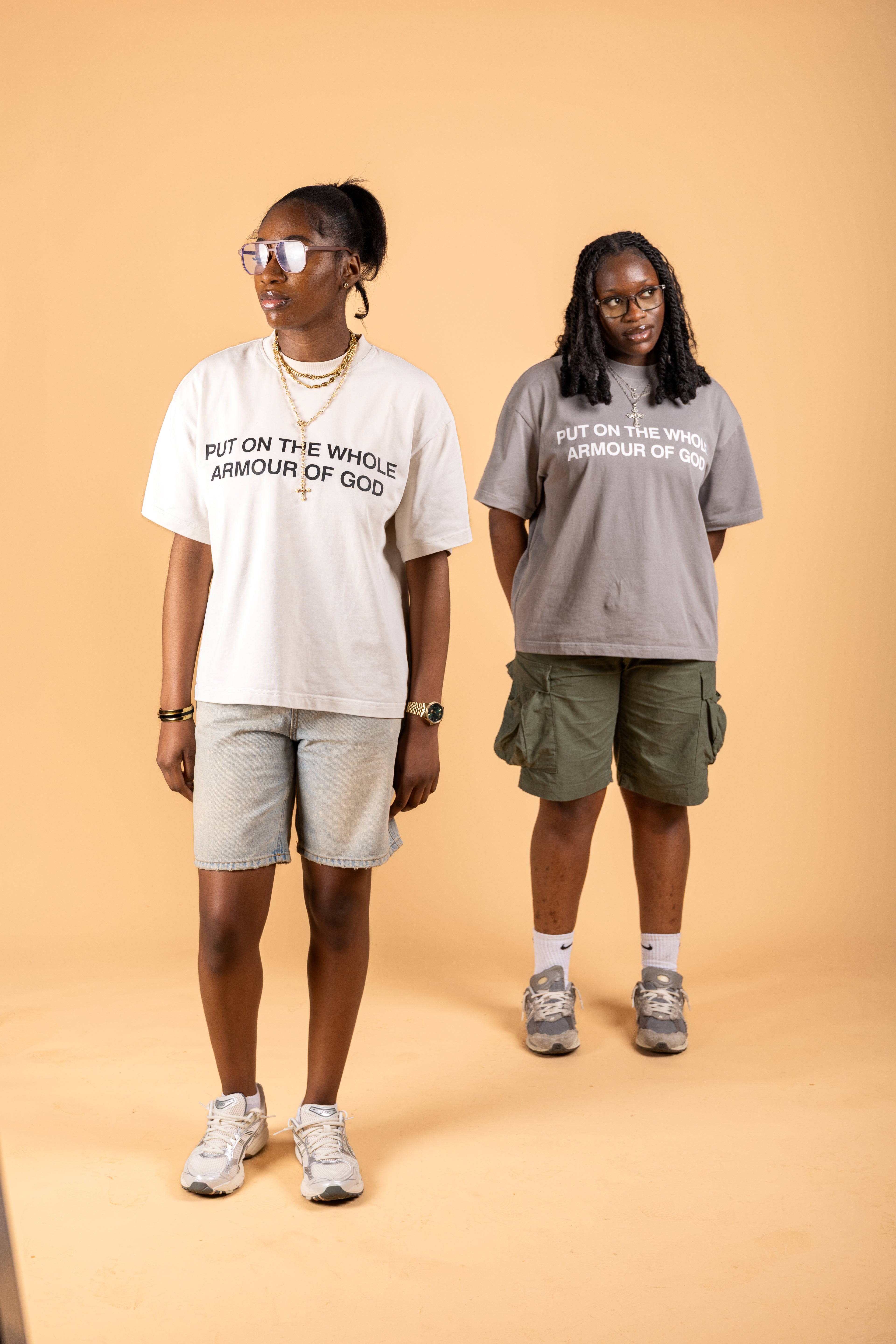 Two people wearing t-shirts with 'Put on the whole armour of God' text on a beige background